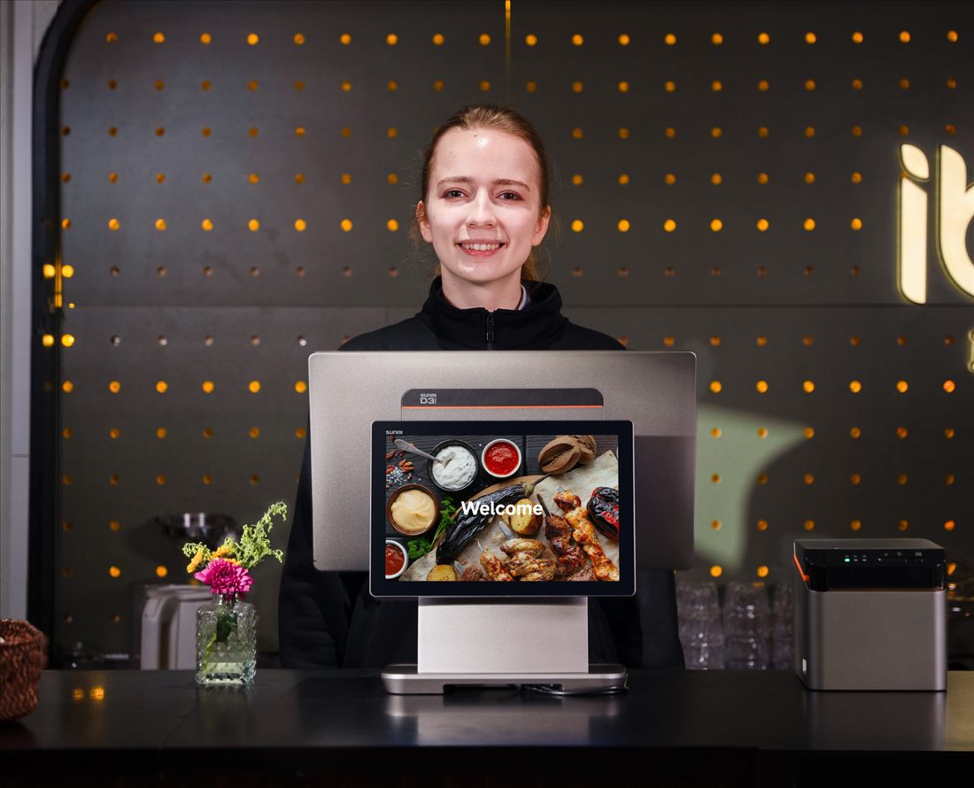 Kellnerin begr&uuml;&szlig;t G&auml;ste mit dem SUNMI D3 PRO im Restaurant